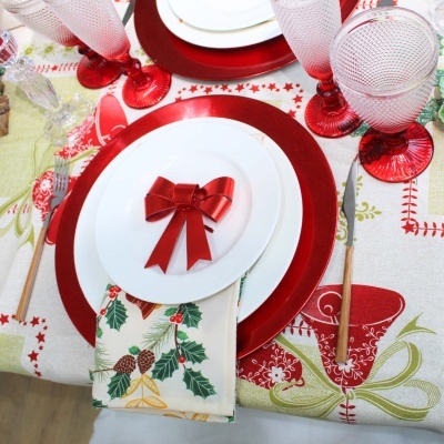 Mesa decorada para Natal com pratos, guardanapo, talheres, copos e toalha temática