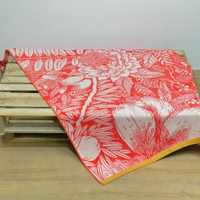 Toalha floral vermelha e branca com borda amarela sobre palete de madeira