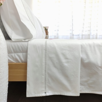 Conjunto de roupa de cama branca com detalhe decorativo