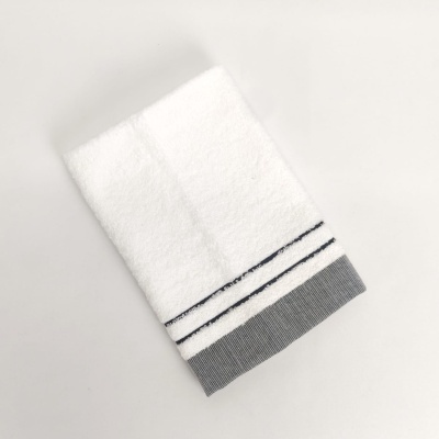 Toalha branca com riscas pretas e borda cinza