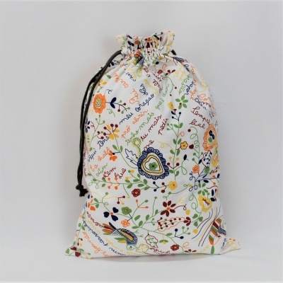 Saco de pano branco com padrão floral colorido e cordão preto