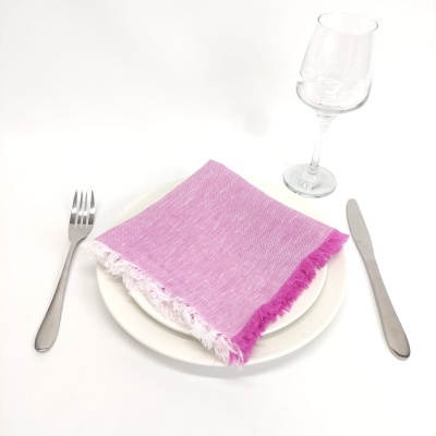 talheres, guardanapo rosa, prato branco, taça de vidro em fundo branco