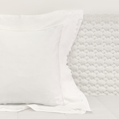 Almofadas brancas decorativas sobre cama branca