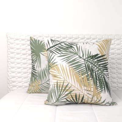 Almofadas com padrão de folhas tropicais em sofá branco acolchoado