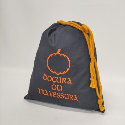 Saco preto com cordão amarelo e impressão laranja de abóbora e texto