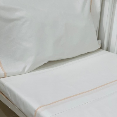 Roupa de cama branca para berço com detalhes bege