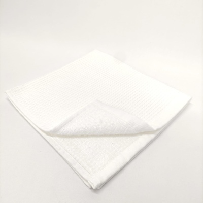 Toalha branca quadrada com textura e face felpuda.