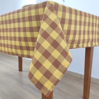 Toalha de mesa xadrez amarelo e castanho numa mesa de madeira
