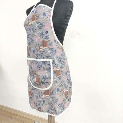 Avental com padrão de veados e folhagens em tons de azul, branco e castanho com bolso frontal