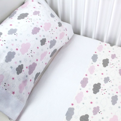 Jogo de cama branco com padrão de nuvens e estrelas em rosa e cinza