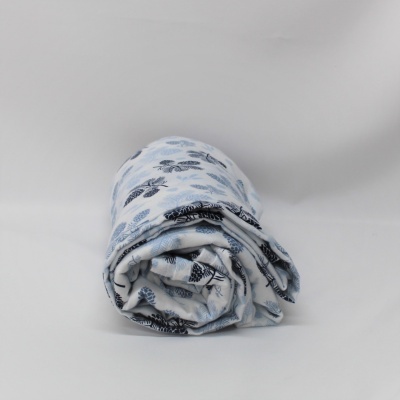 Manta enrolada branca com padrão de folhas azuis