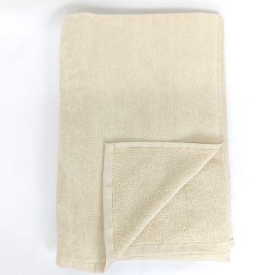 Toalha creme em tecido felpudo dobrada