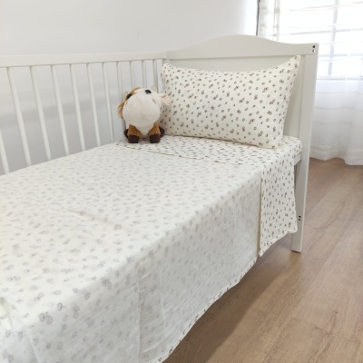 Cama infantil branca com roupa de cama branca estampada e brinquedo de pelúcia