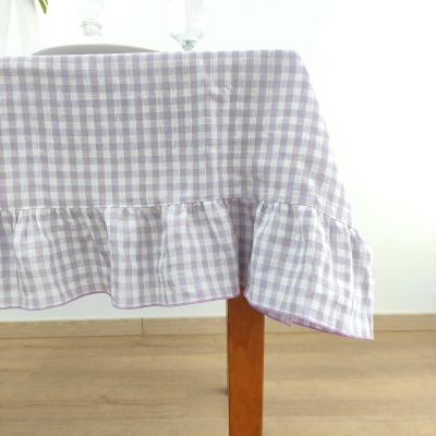 Toalha de mesa lilás e branco com babado em mesa de madeira
