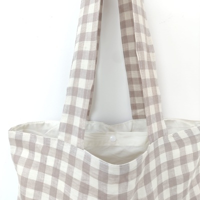 Mala tote de algodão bege e branco com padrão xadrez e botão de pressão