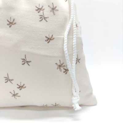 mochila saco bege com padrão de libélulas castanhas e cordão branco