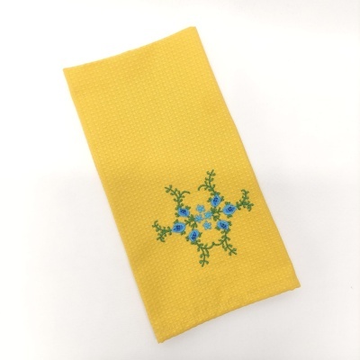 Guardanapo amarelo com bordado de flores azuis