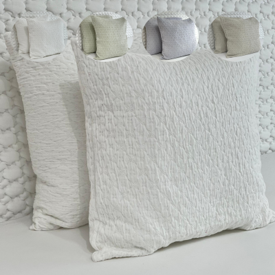 Almofadas texturizadas em várias cores sobre superfície branca