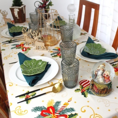 Mesa de jantar decorada com toalha natalícia e acessórios temáticos