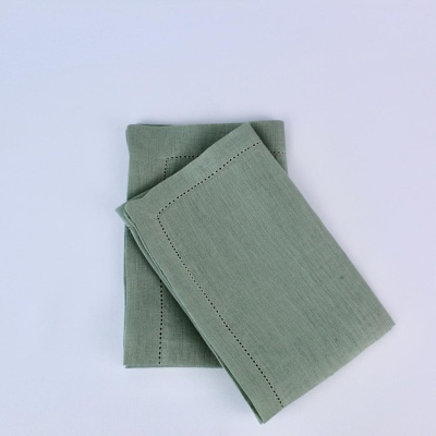 Dois guardanapos de tecido verde claro com padrão de pontos abertos