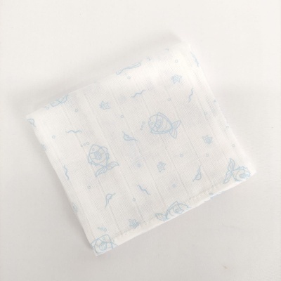 Fralda branca com padrão azul de peixes e ondas