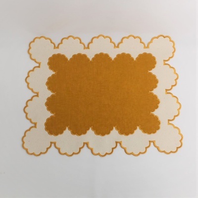 Jogo americano creme e laranja com bordas recortadas em padrão de nuvens