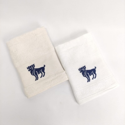 Duas toalhas de mão, bege e branca, com bordado azul escuro de cão.