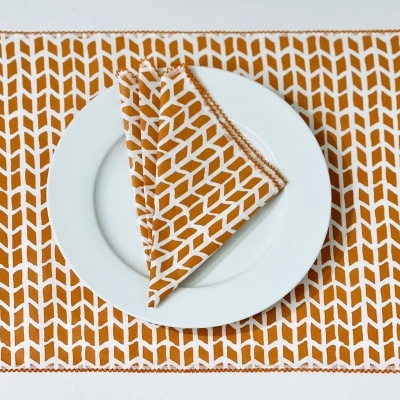 Jogo americano e guardanapo decorativo em padrão geométrico branco e mostarda com prato branco