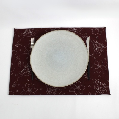 Jogo americano vermelho vinho com padrão floral e prato branco com talheres