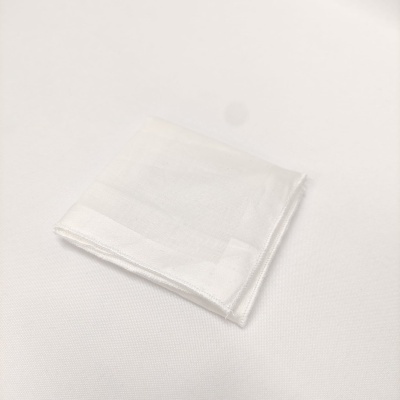 Guardanapo branco de tecido dobrado sobre superfície branca