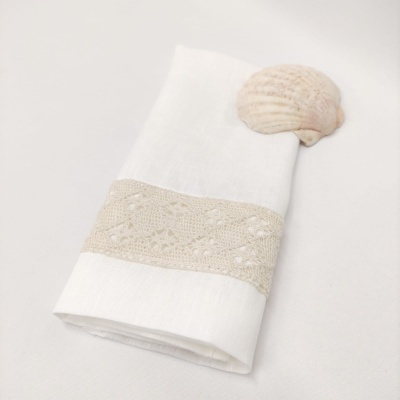 Guardanapo branco com faixa de renda bege e concha do mar clara