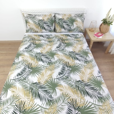 Conjunto de cama com padrão de folhas verdes e amarelas sobre fundo branco