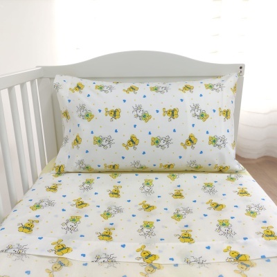 Roupa de cama infantil com ursinhos amarelos e flores azuis em cama branca