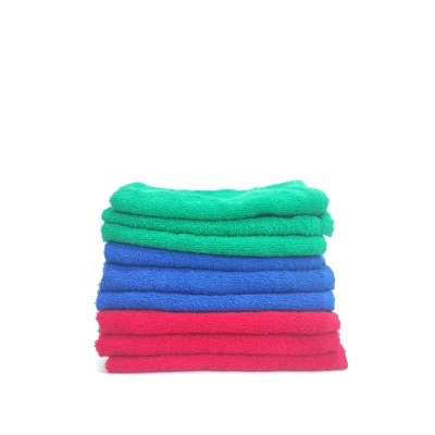 Toalhas empilhadas em verde, azul e rosa