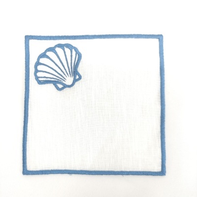 Guardanapo branco com borda azul e concha bordada azul.