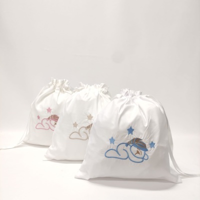 Três sacos de tecido branco bordados com nuvem, estrela e bebê, em rosa, bege e azul