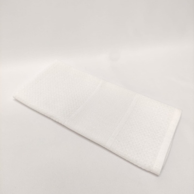 Toalha branca retangular sobre superfície branca