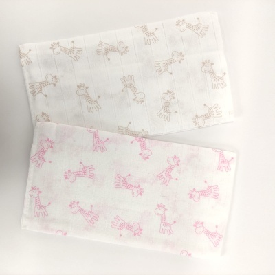 Dois panos brancos com padrão de girafas cor-de-rosa e castanhas