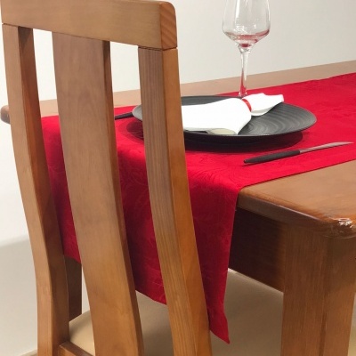 Mesa de madeira com toalha vermelha e utensílios de jantar
