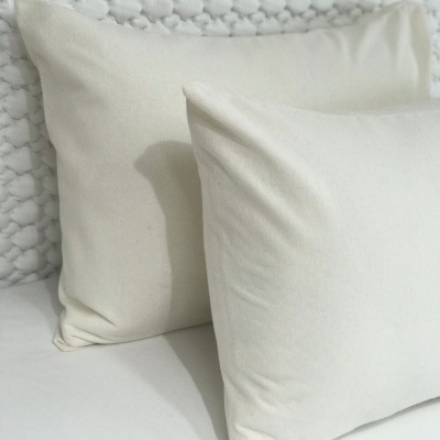 Dois almofadas brancas com tecido macio sobre superfície e fundo brancos