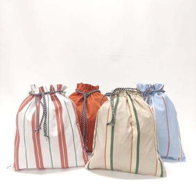 Quatro sacos de tecido listrados com cordões de fecho trançados