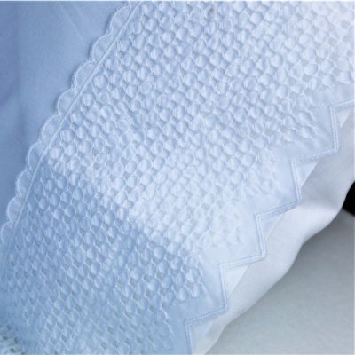 Almofada branca com bordado geométrico em relevo e costura ziguezague