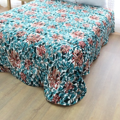 Colcha de cama com padrão floral em tons de azul, verde e vermelho