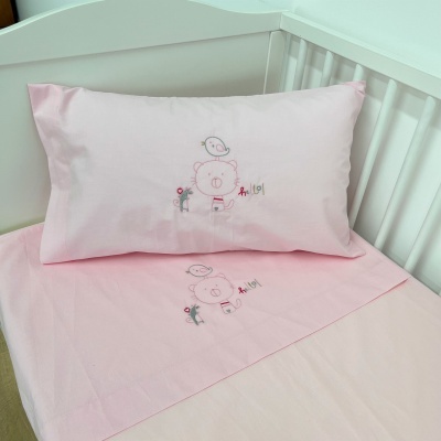 Jogo de cama rosa claro com bordados de ursinho e passarinho em berço branco