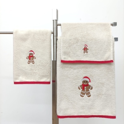 Toalhas bege com bordas vermelhas e bordado de biscoito de gengibre com gorro e cachecol vermelho