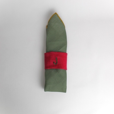 Guardanapo verde com anel vermelho com letra J