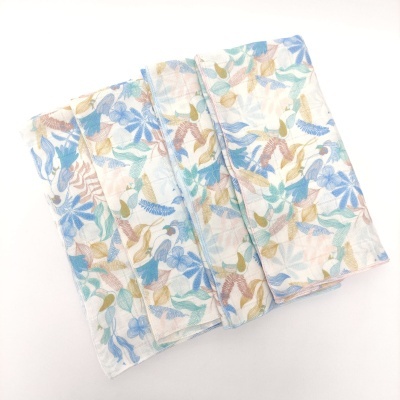 Toalha de tecido com padrão floral azul, castanho, verde e bege dobrada