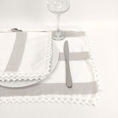 Conjunto de guardanapo e toalha branca com renda e padrão cinzento, com prato, faca e taça