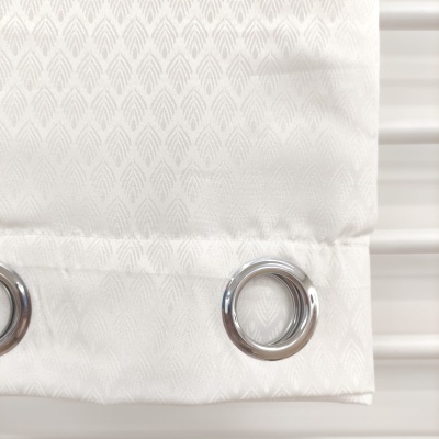 Cortina branca texturizada com argolas metálicas prateadas.