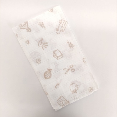 Toalha branca com desenhos bege claros de objetos diversos sobre fundo branco